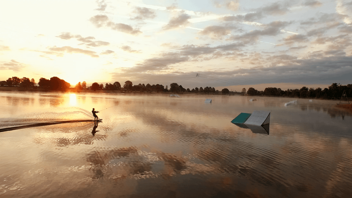 Wasserskifahrer:in im Sonnenuntergang