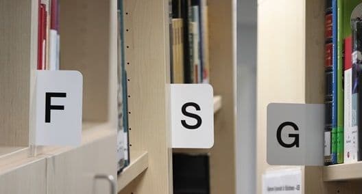 a row of bookshelves with labels on them that say f , s , and g