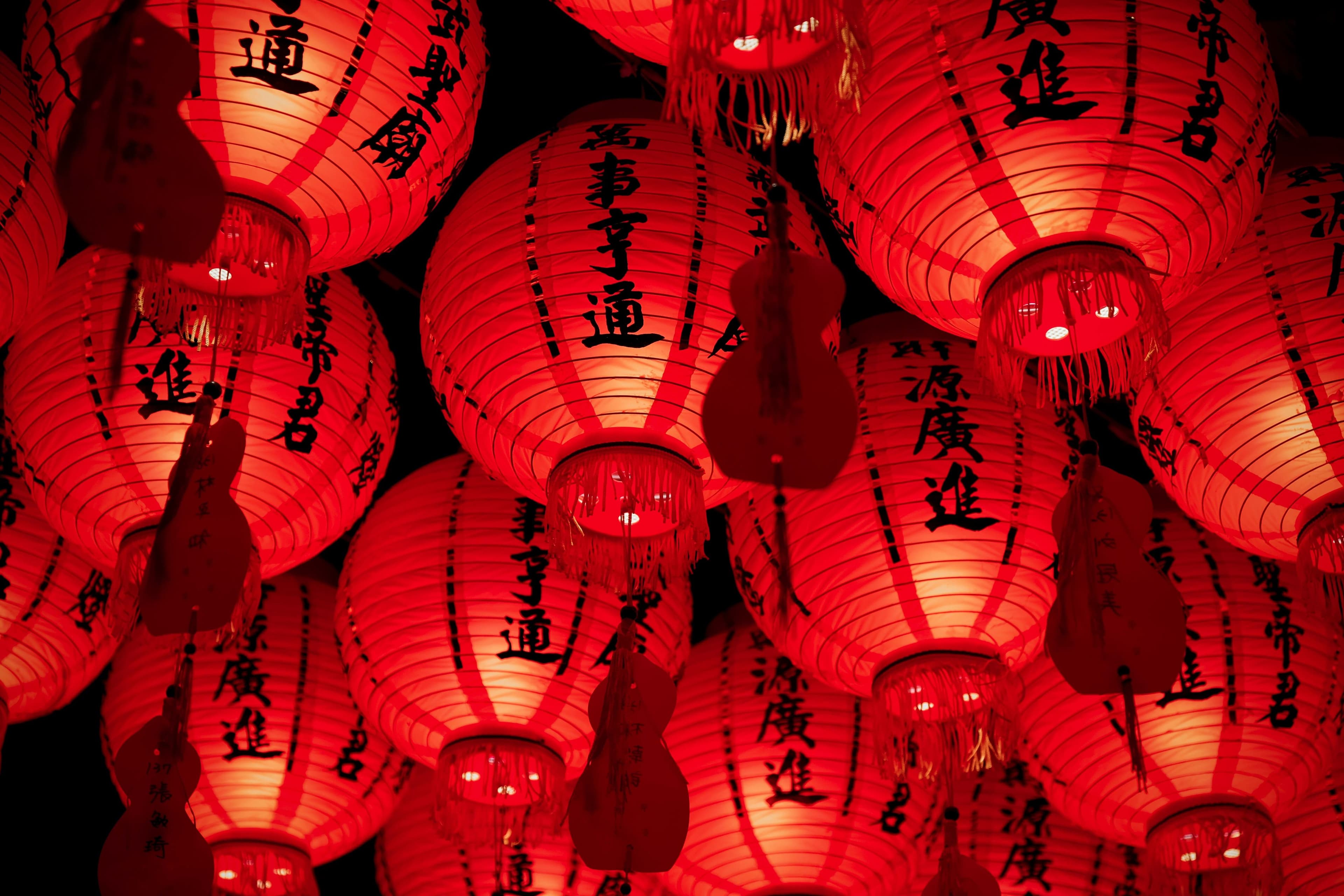 Rot leuchtende chinesische Lampions mit chinesischen Schriftzeichen.