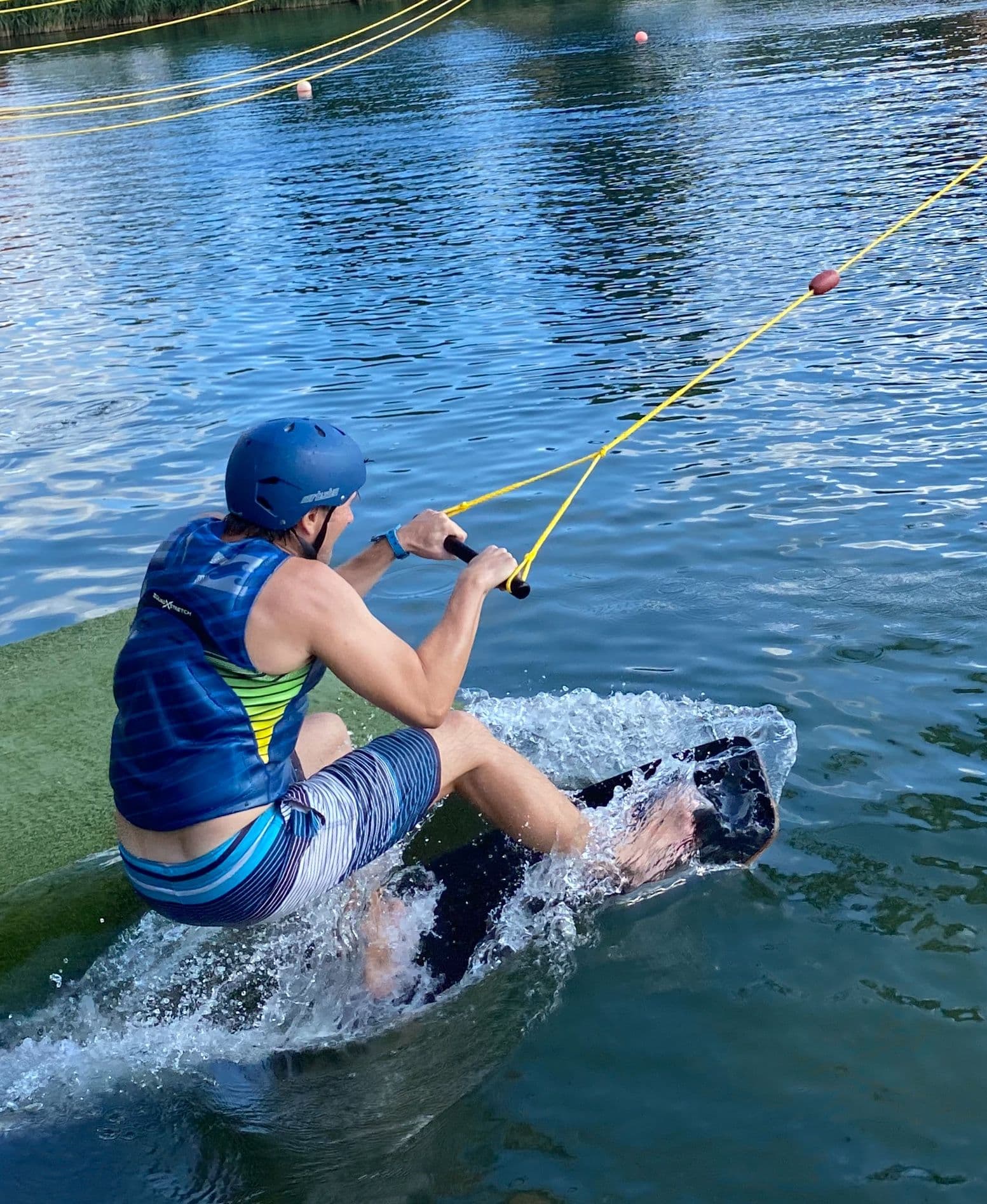 Eine Person fährt Wakeboard oder Wakeskate an einem See